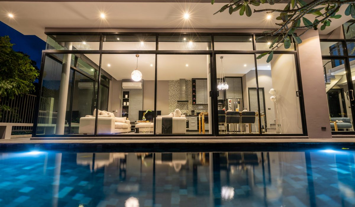 night exterior home with swimming pool in the house